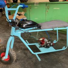 A robin's egg blue mini-bike frame in the process of being constructed in a full bike.