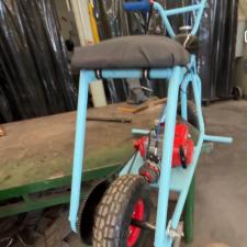 A robin's egg blue mini-bike with a black seat upholstered in old ski pants. 