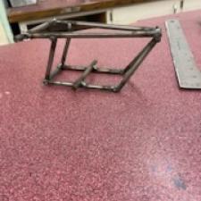 A mini-bike frame with no parts added yet. Under construction.