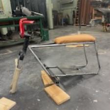 A mini-bike in the process of being assembled. The seat  is upholstered in a goat skin from a local farm.