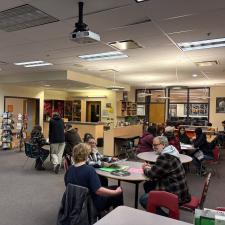 Students and parents seated at chairs in a school library